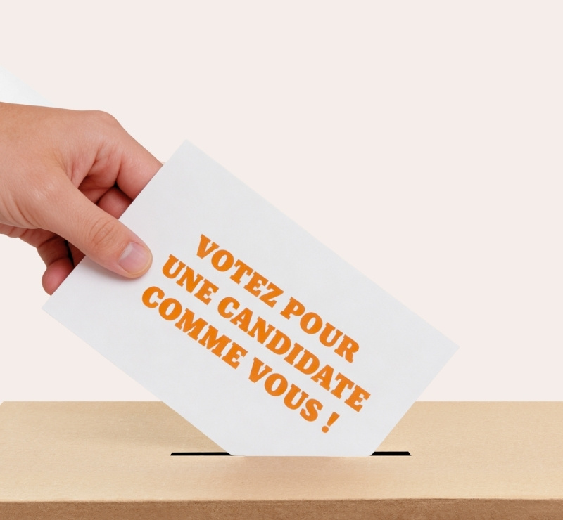 personne dont on na voit que le bras et la main en train de glisser un bulletin de vote dans une urne